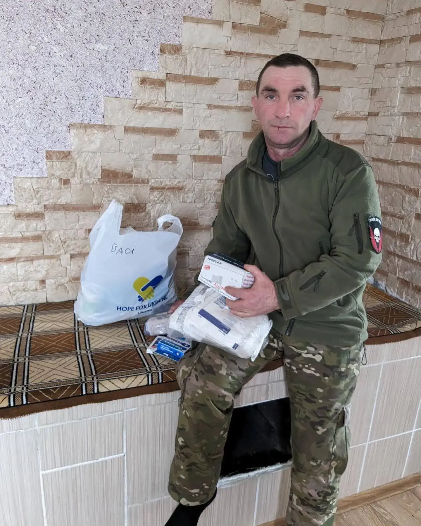 a man sitting on top of a counter next to a bag.