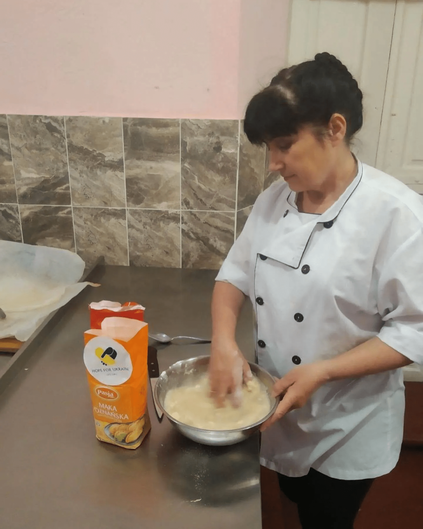 a woman in a chef's coat is making food.