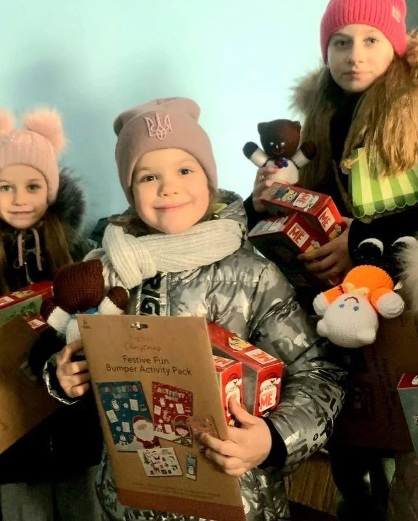 a group of young children holding christmas presents.