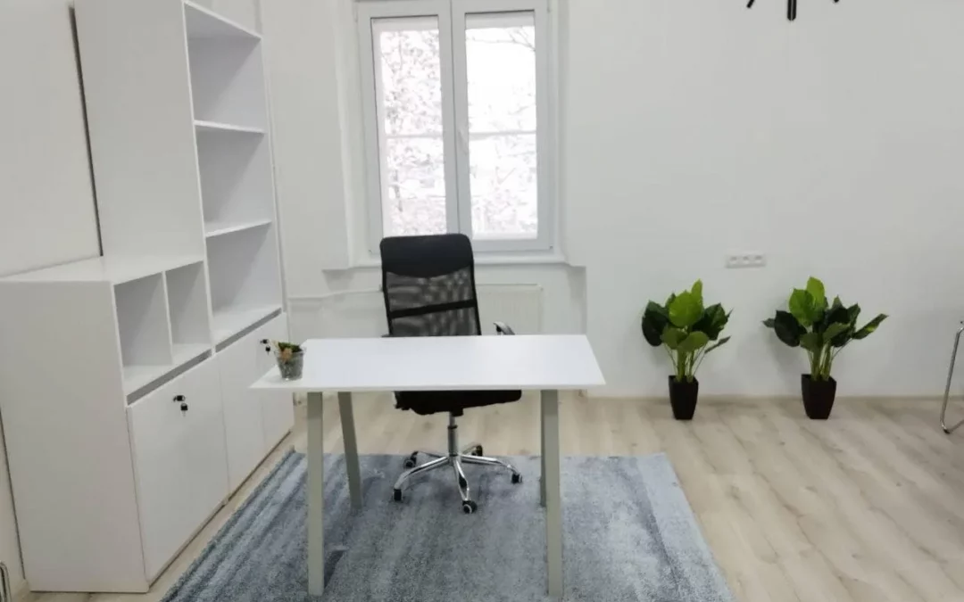 a room with a desk, chair and a clock on the wall.