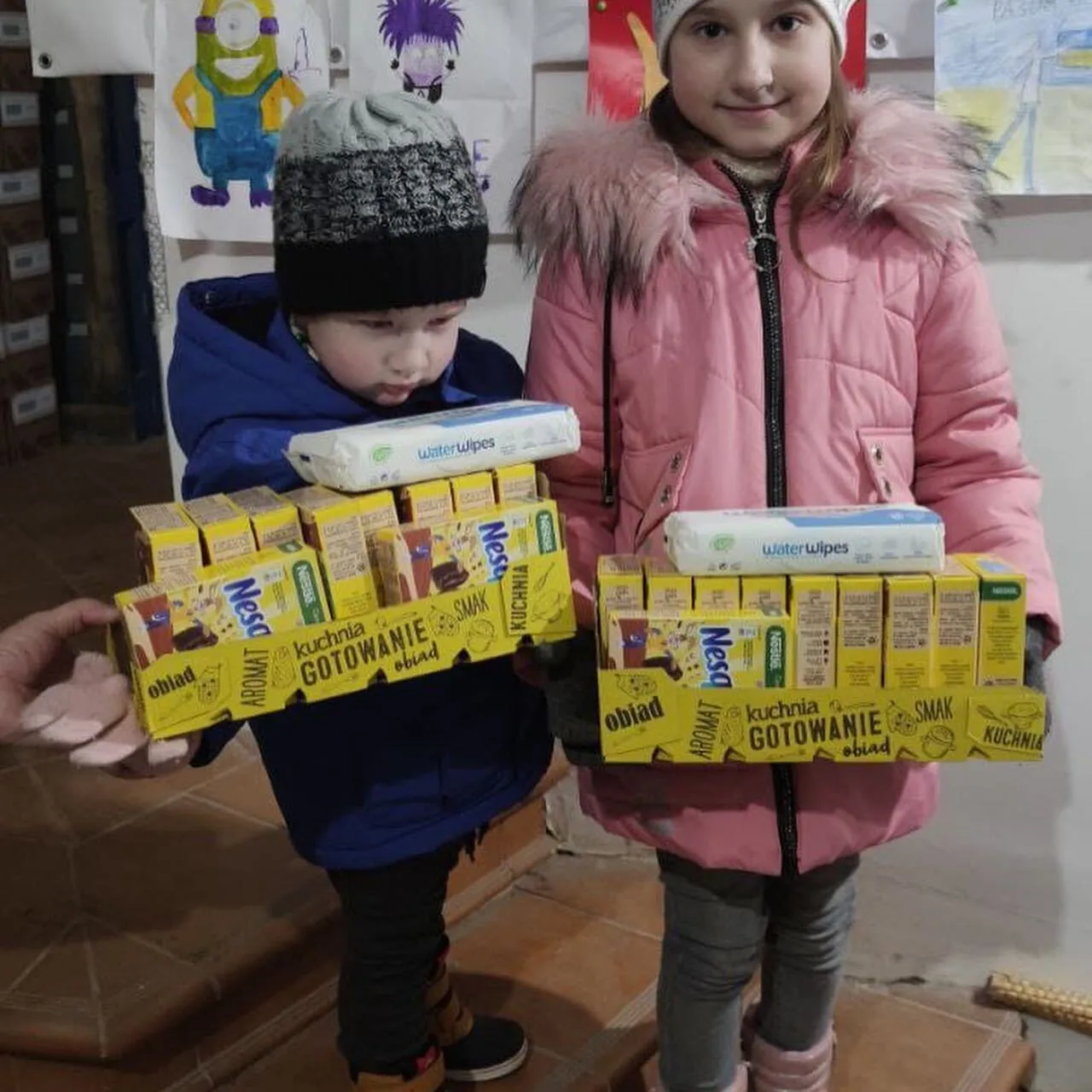 a boy and a girl holding boxes of food.