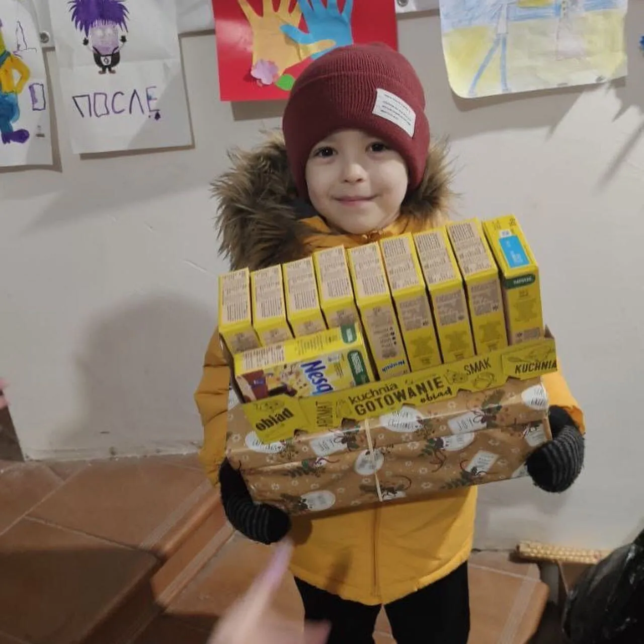 a young boy holding a box of brownies.