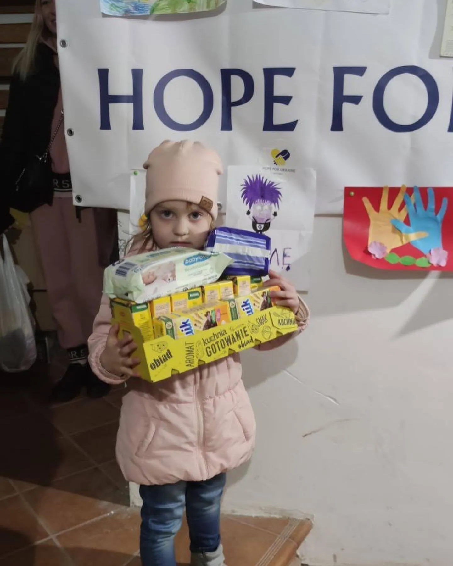 a little girl holding a box of hope foods.