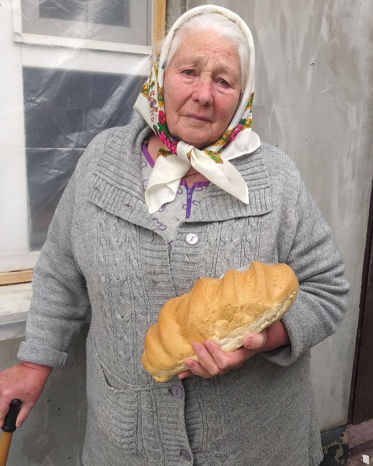 a woman holding a loaf of bread in her hands.
