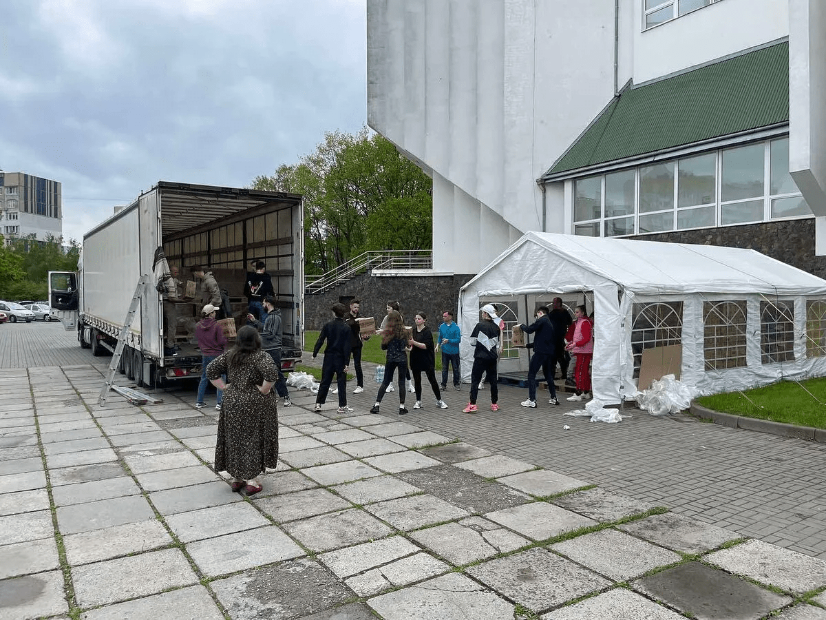 a group of people standing in front of a truck.