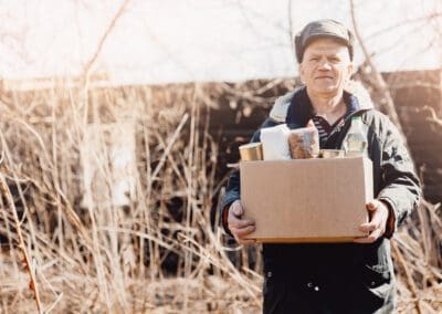 a man holding a box of food in a field.