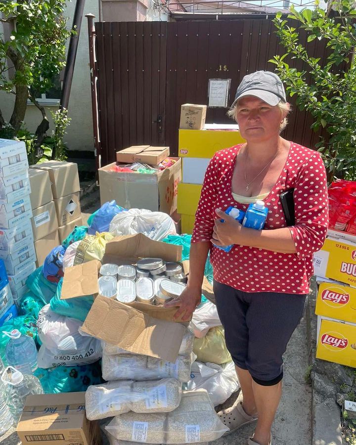 a woman standing next to a pile of bottled water.