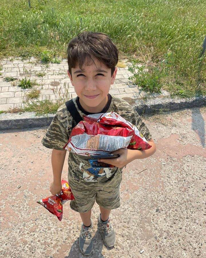 a young boy holding a bag of food.