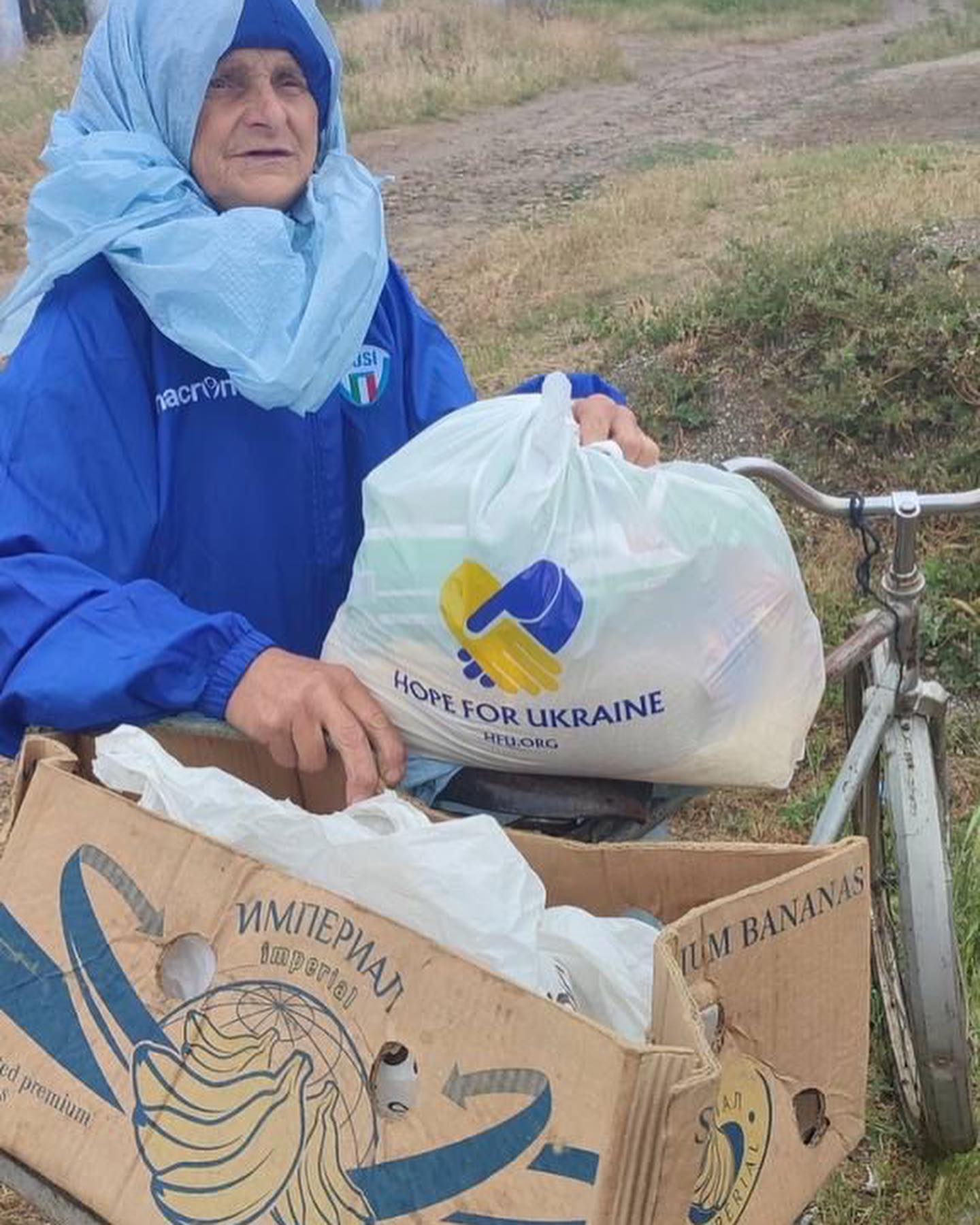 a woman in a blue jacket holding a bag of groceries.