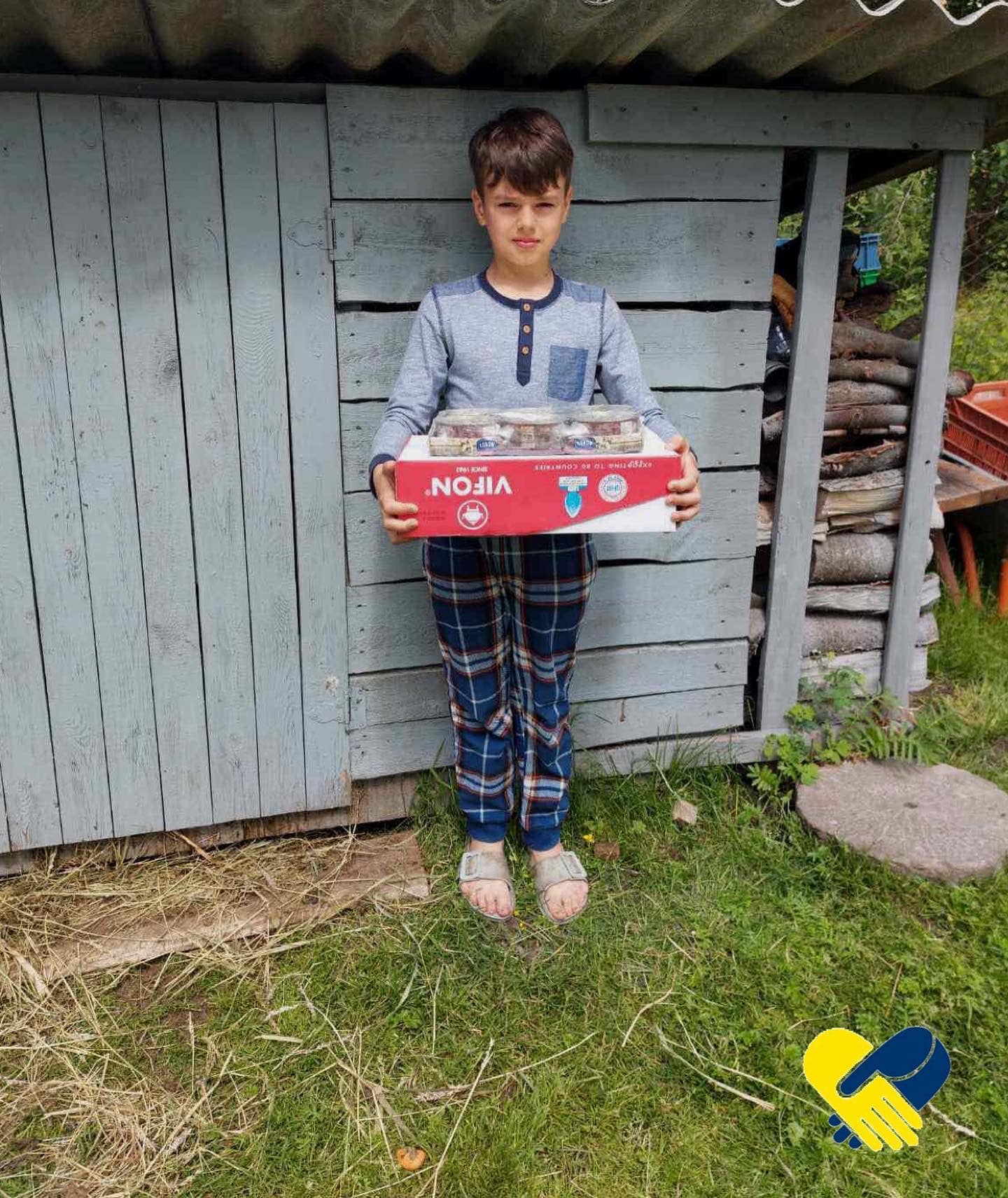 a young boy holding a box of food.