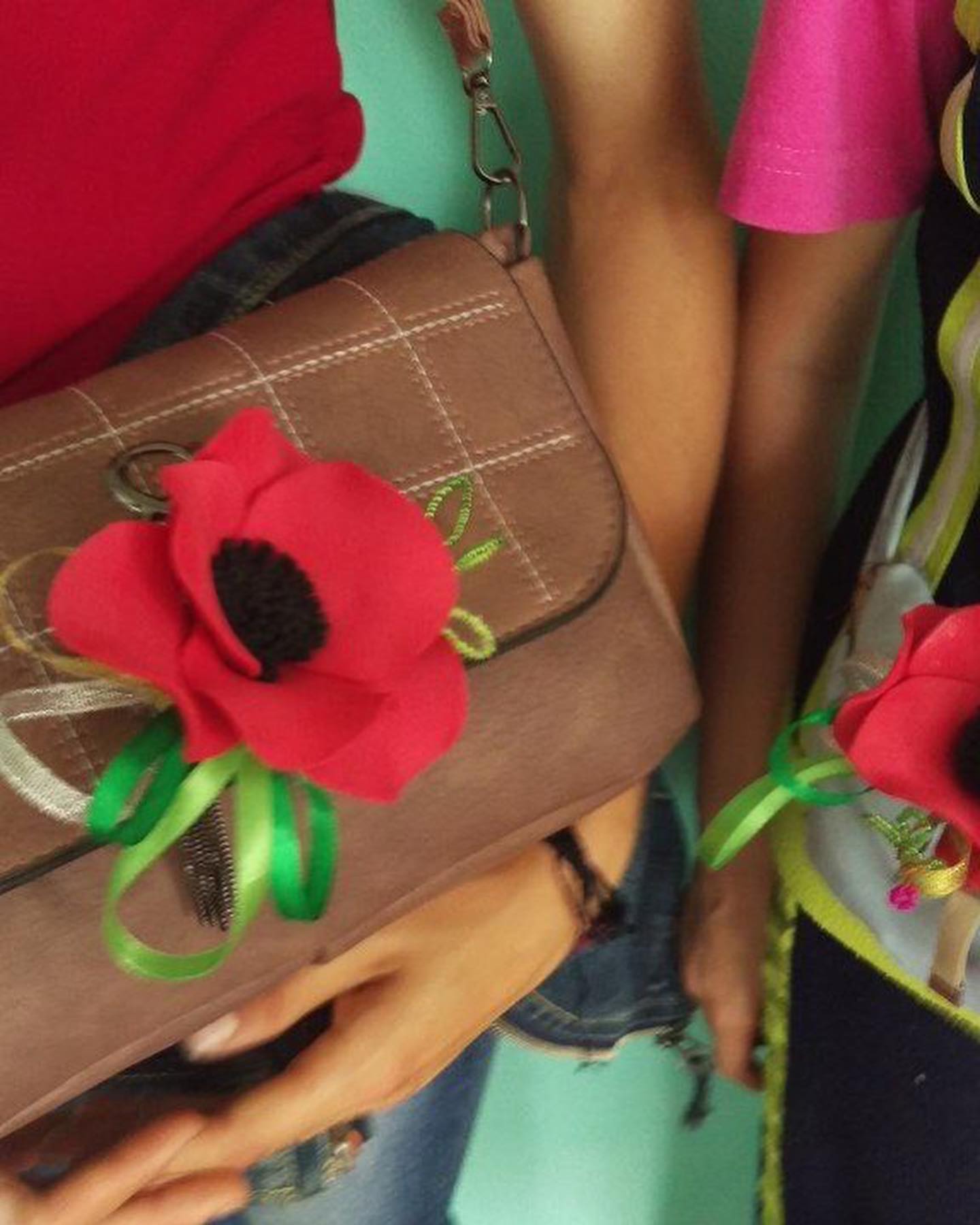 a woman holding a purse with a flower on it.