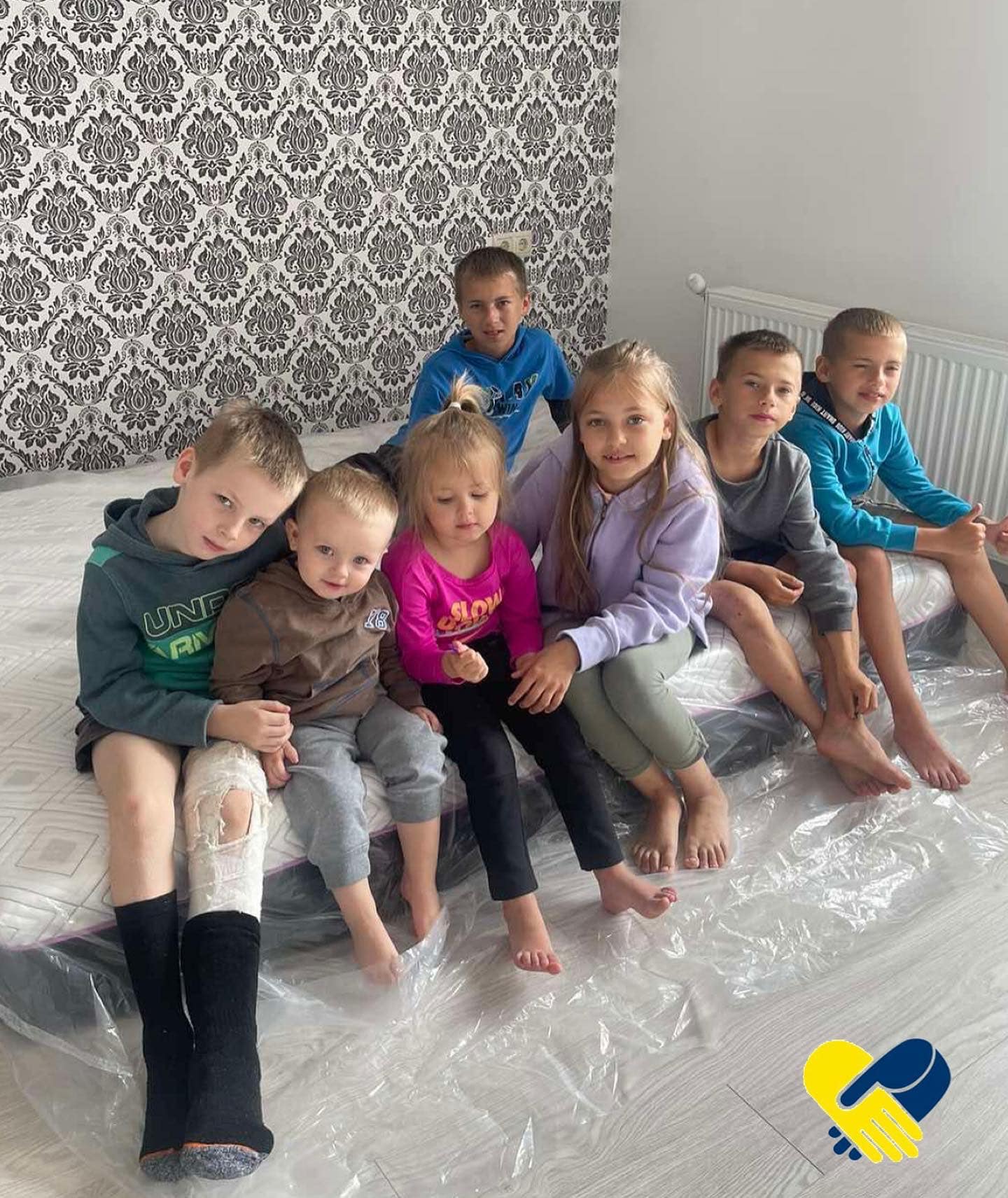 a group of children sitting on top of a bed.