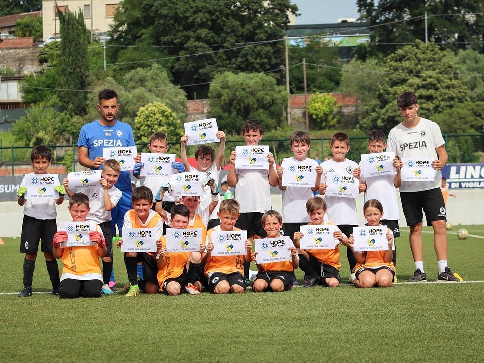 a group of children holding up signs on a soccer field.