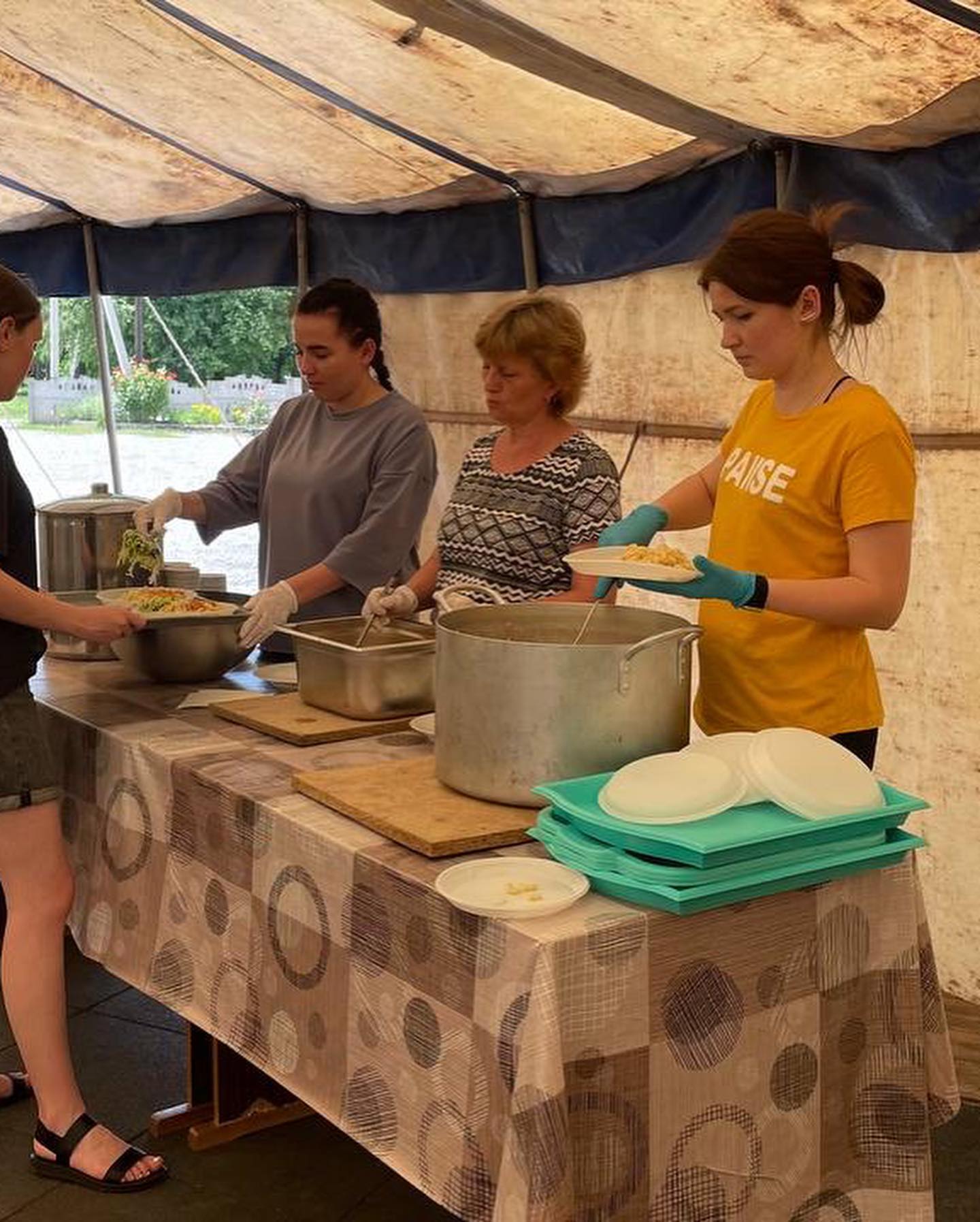 a group of people preparing food inside of a tent.