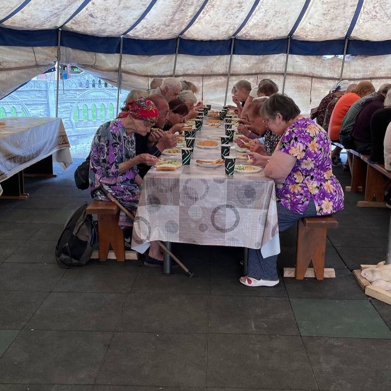 a group of people sitting at a table in a tent.