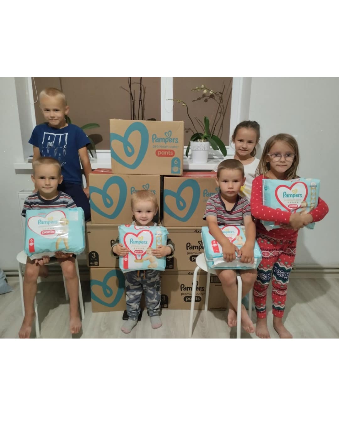 a group of children posing with boxes of diapers.