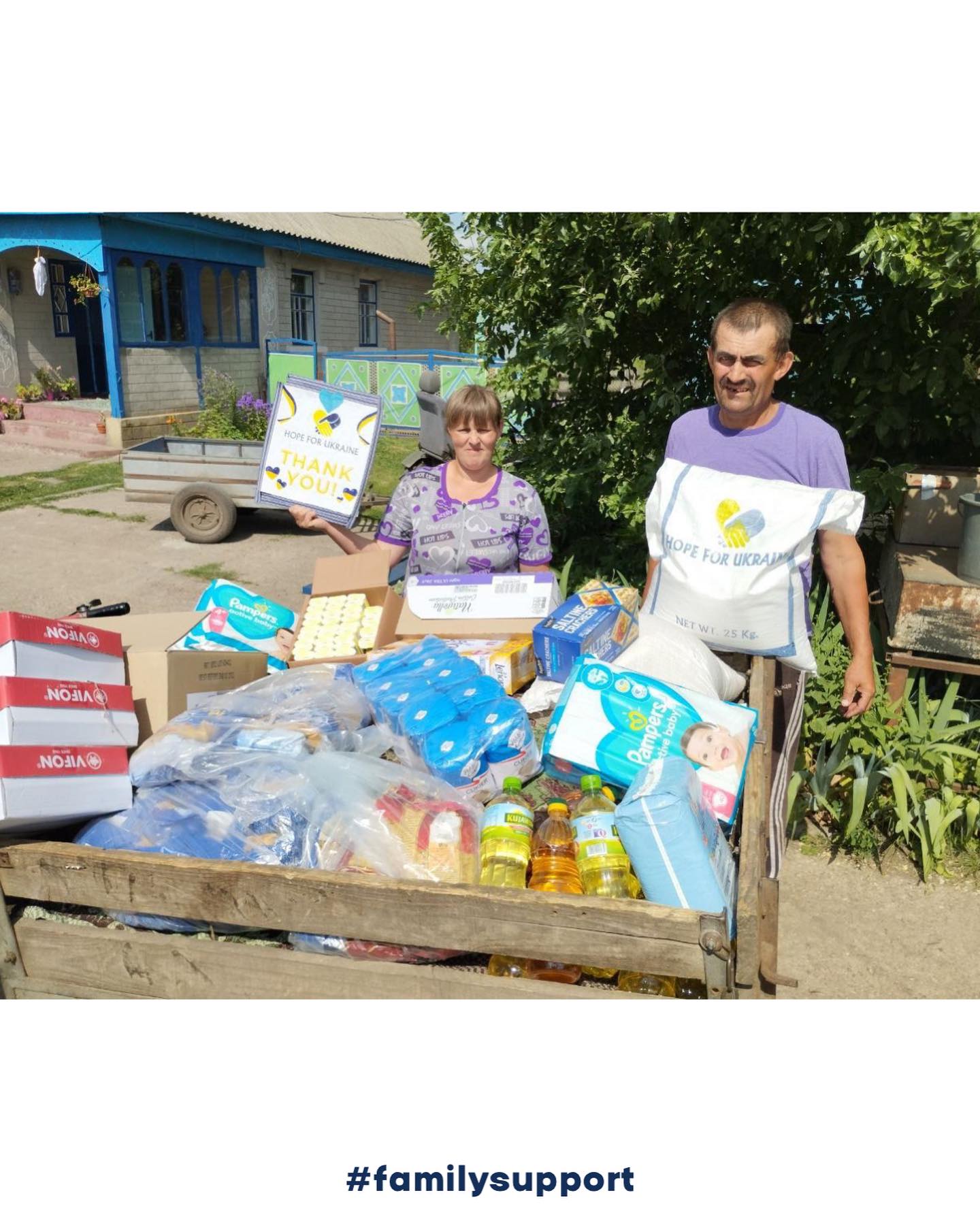 a man and woman standing next to a cart full of diapers.
