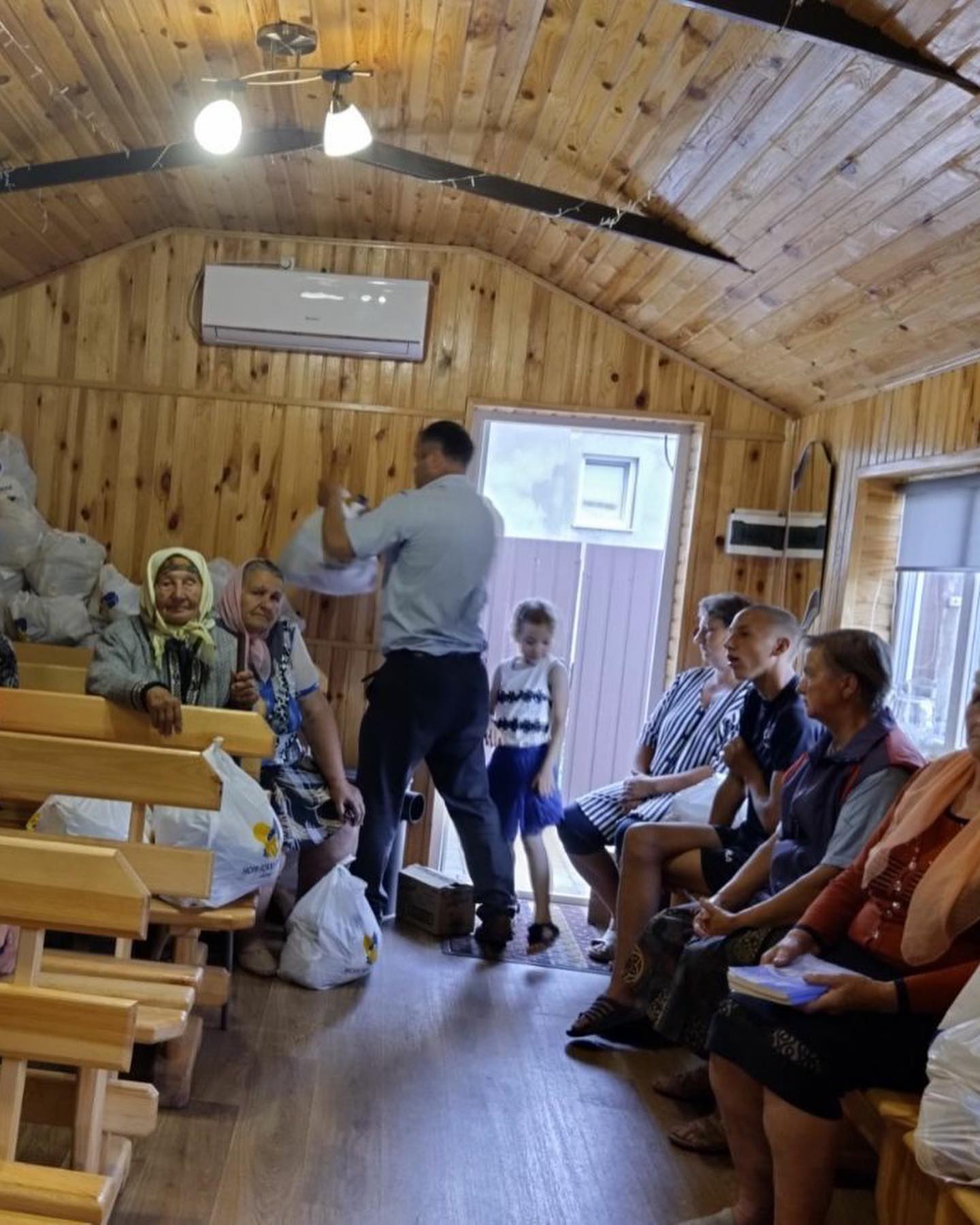 a group of people sitting in a wooden cabin.