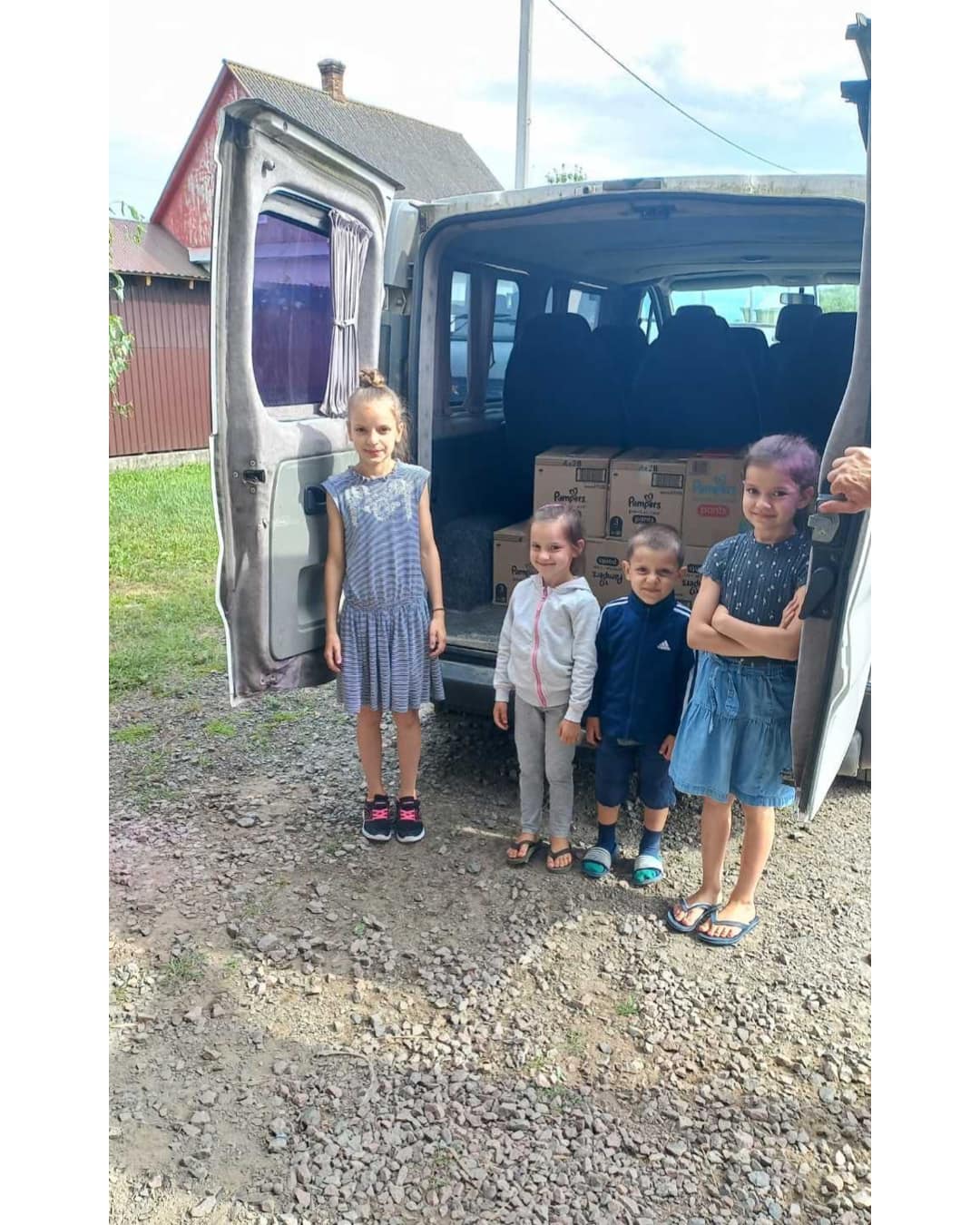 a group of children standing in front of a van.