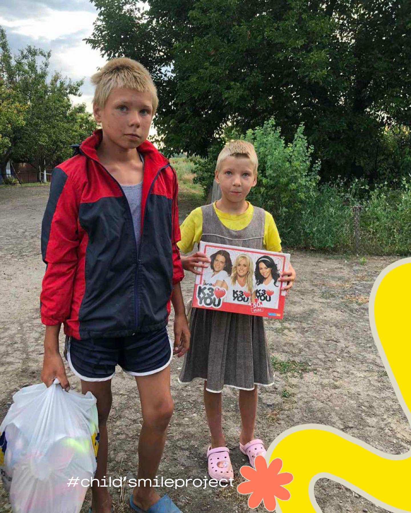 two children standing next to each other holding a sign.