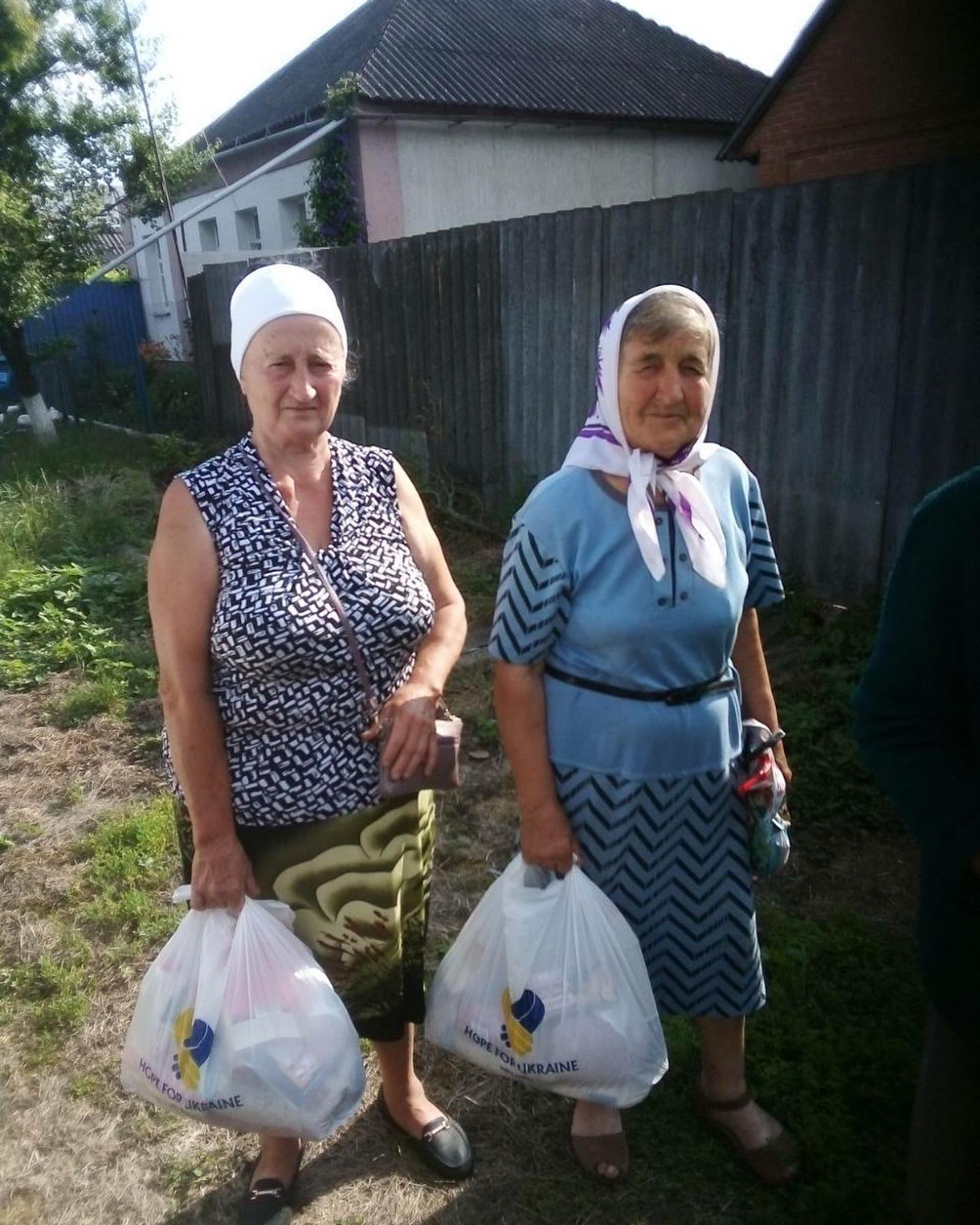 a group of women holding bags of groceries.