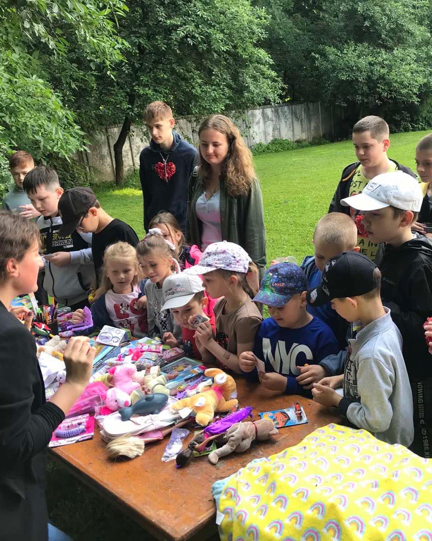 a group of children are gathered around a table with toys.