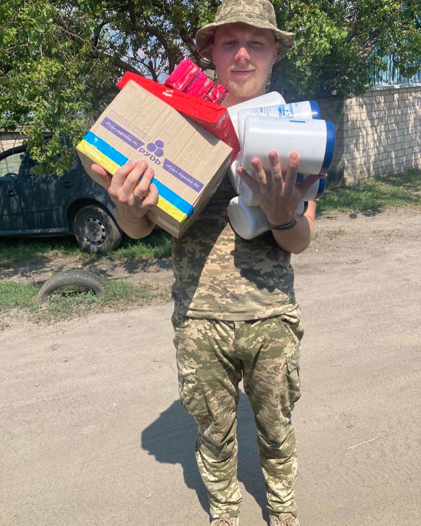 a man in a camouflage hat holding a box.
