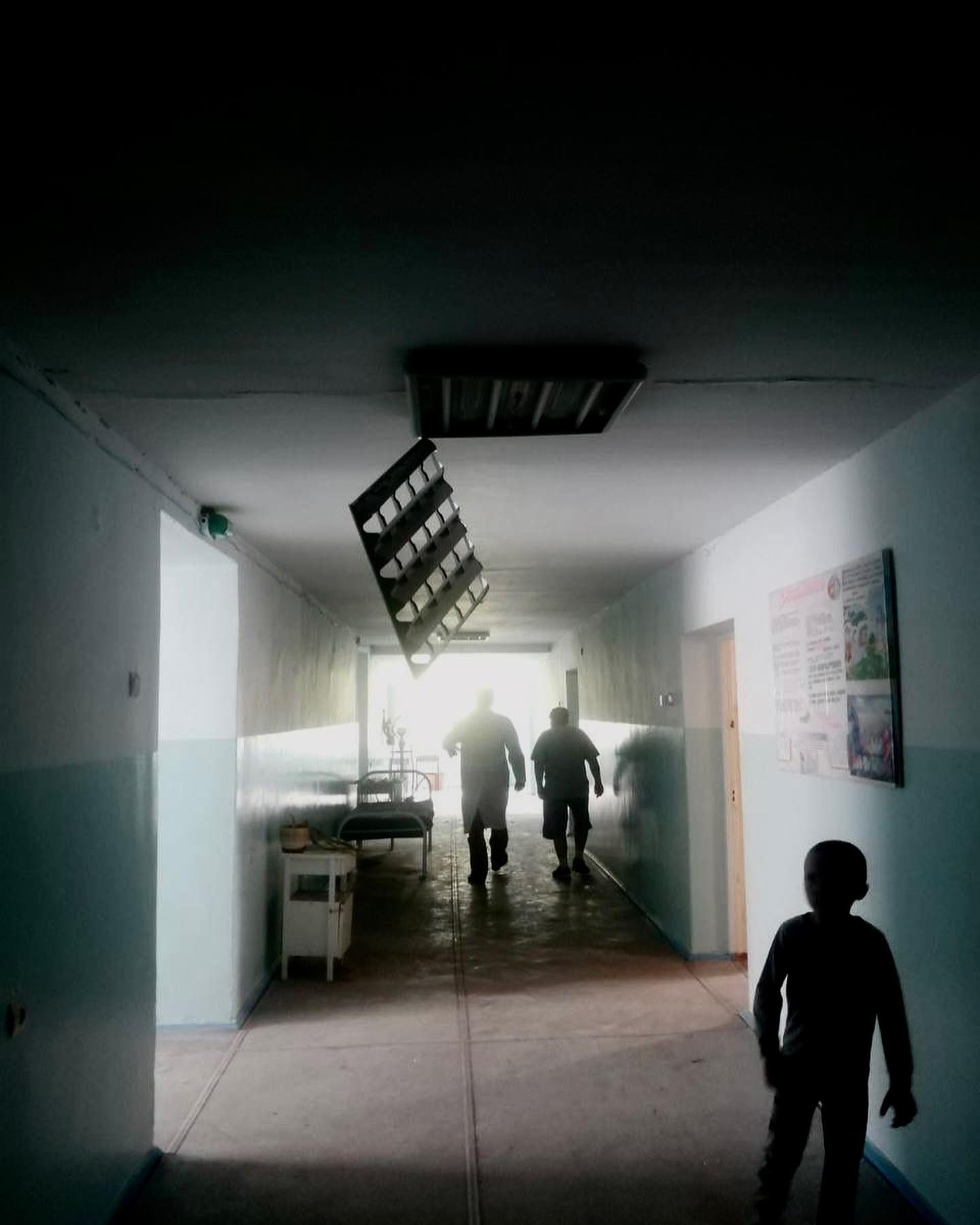two children walking down a hallway in a hospital.