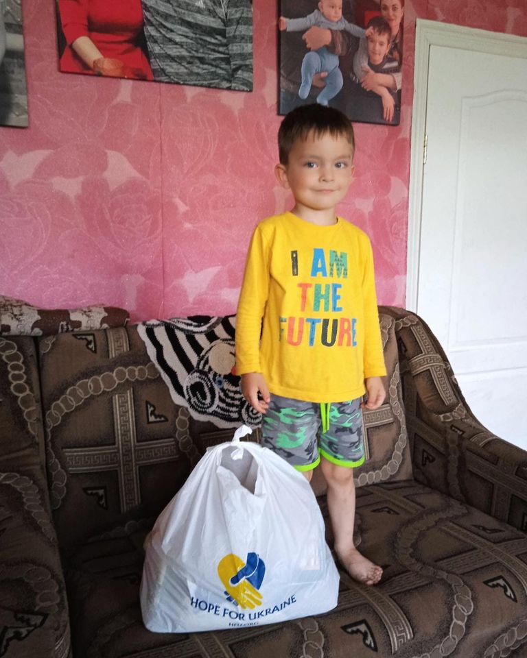 a young boy standing on a couch with a bag.