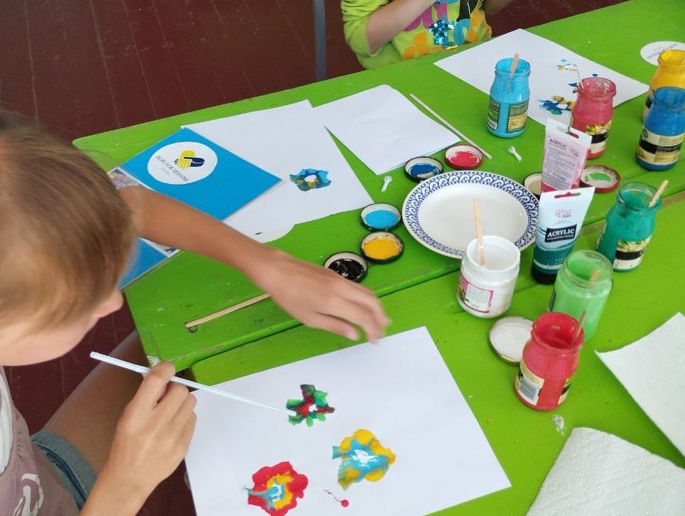 A group of children are painting at a table.