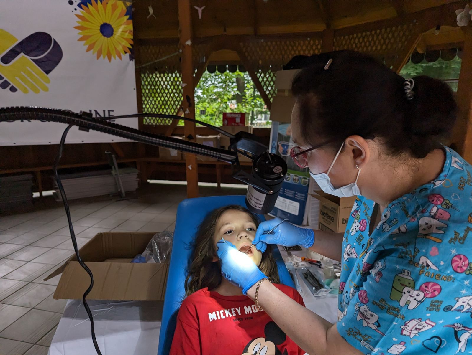 a woman is giving a child a dental exam.