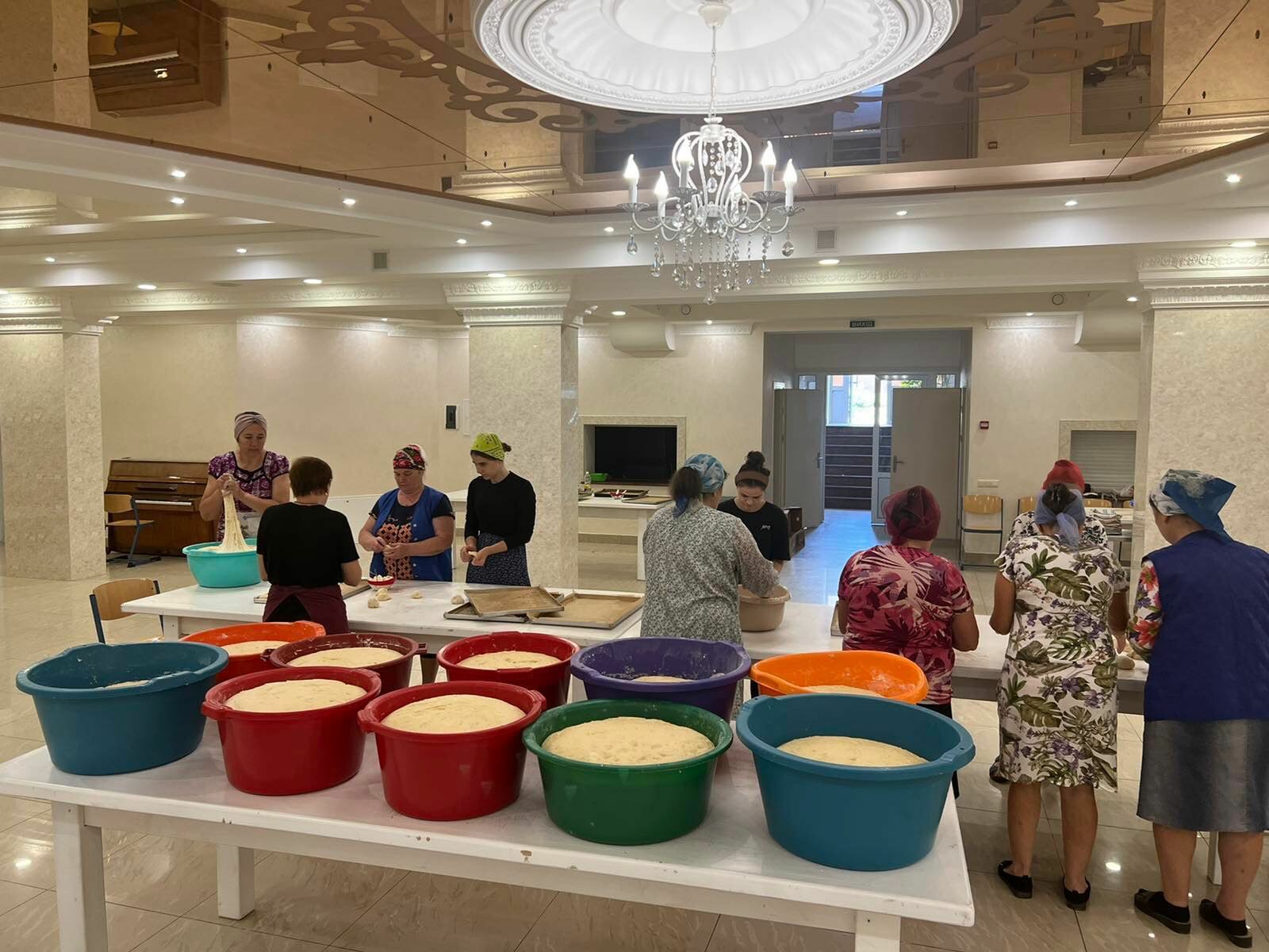 A group of people standing around a table with colorful bowls.