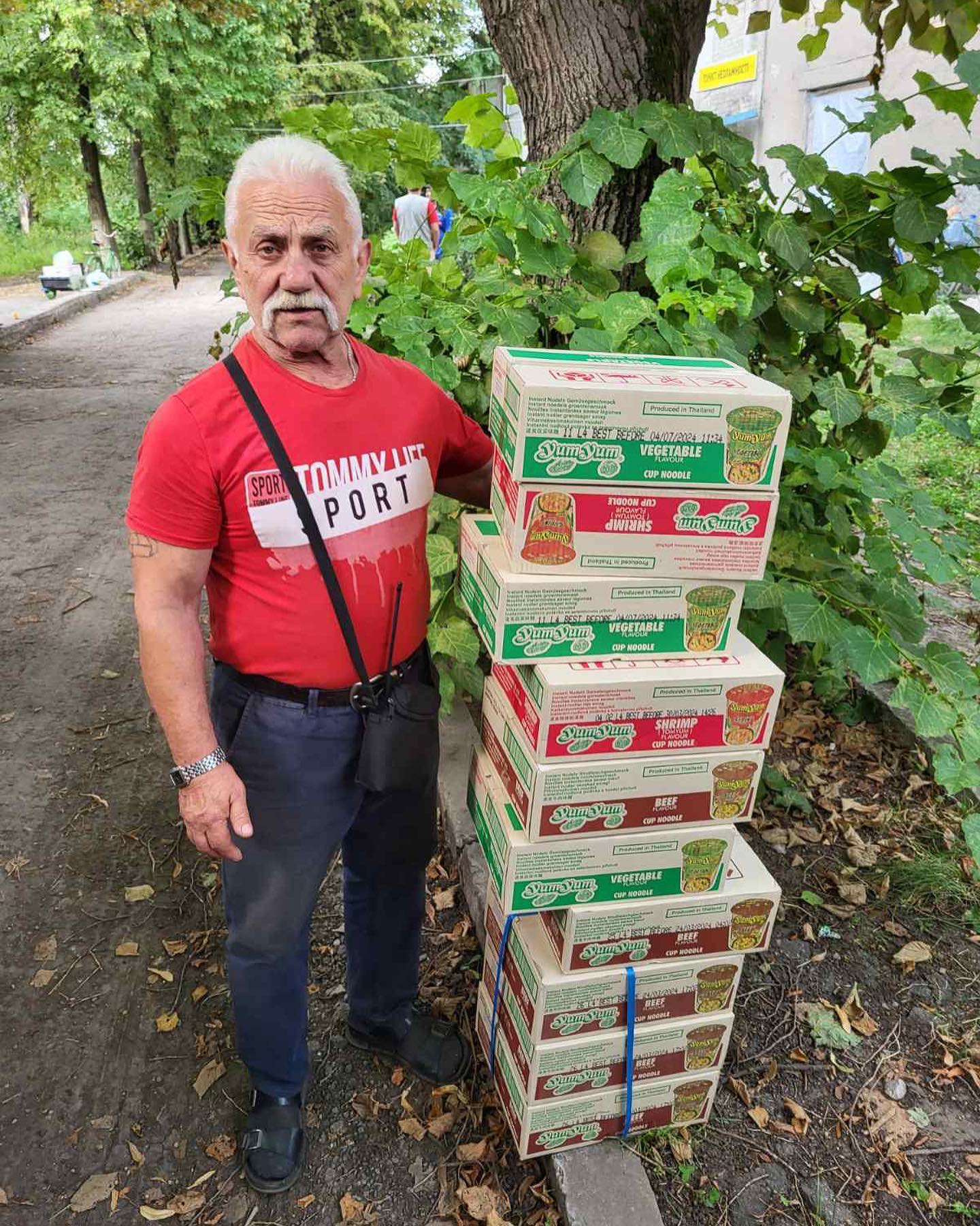 A man standing next to a stack of pizza boxes.