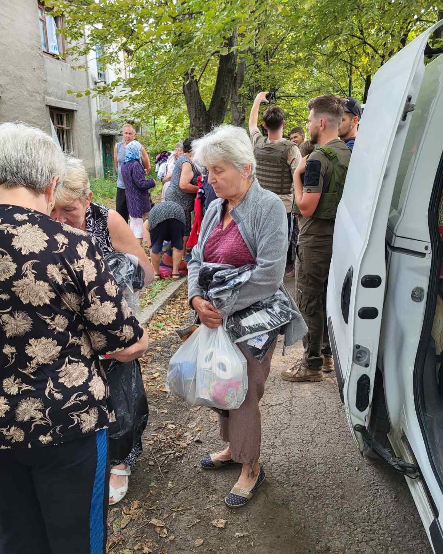 A group of elderly people standing next to a van.