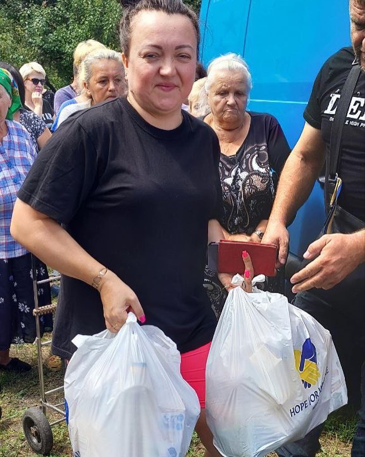 A woman is standing next to a group of people with bags.