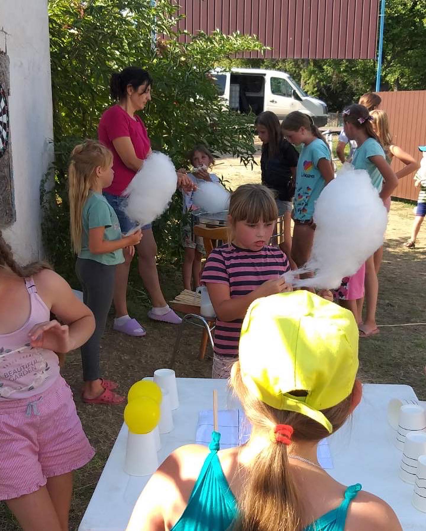 A group of children standing around a table with cotton candy.