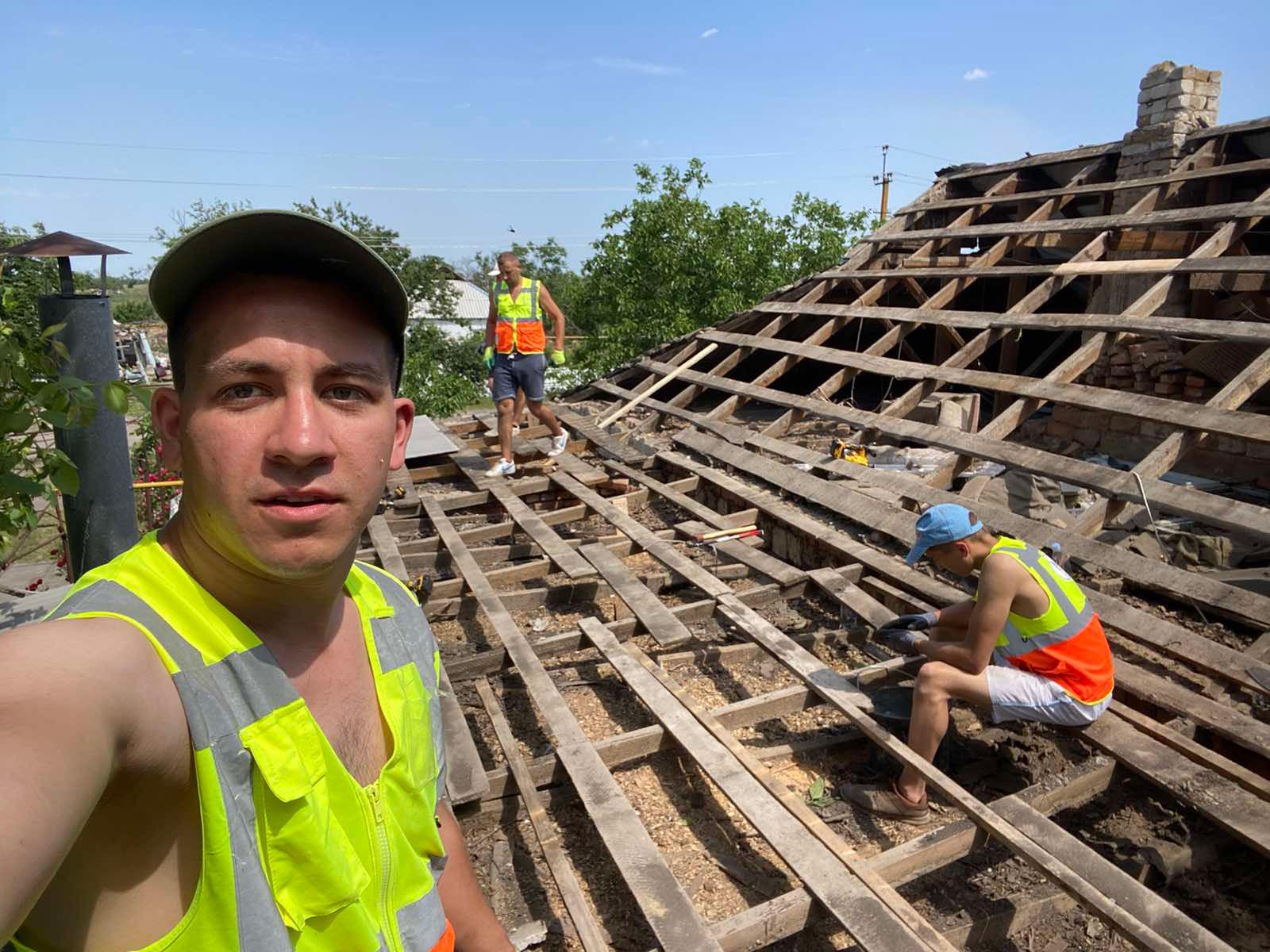A man takes a selfie while working on a roof.