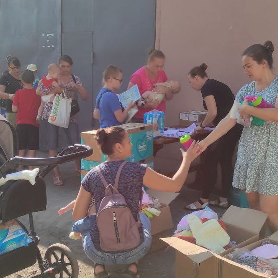 A group of people handing out boxes to a group of people.
