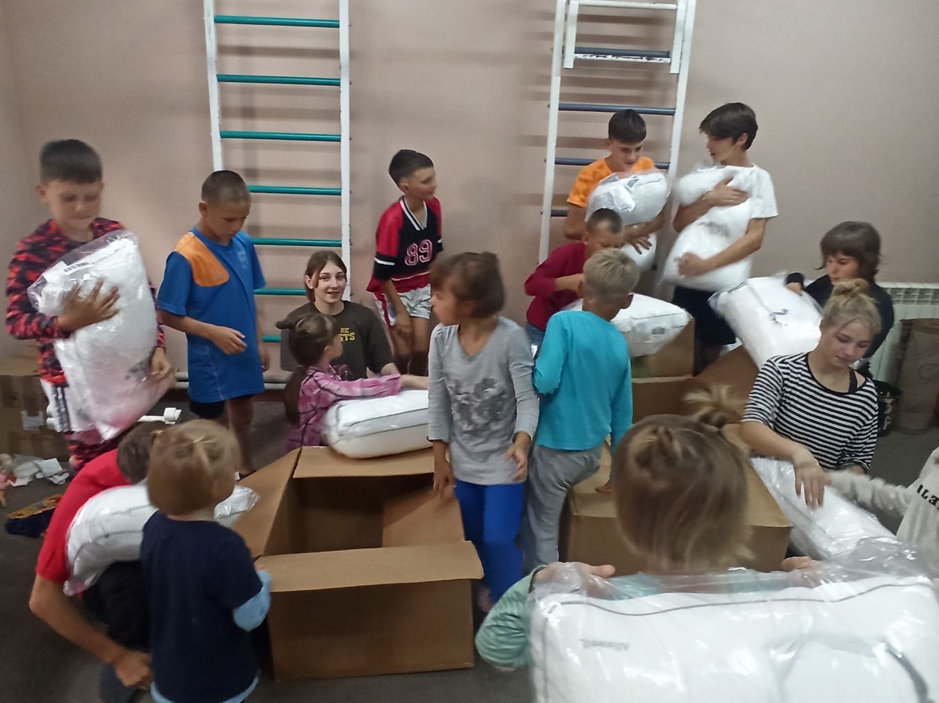A group of children are standing in a room with boxes.
