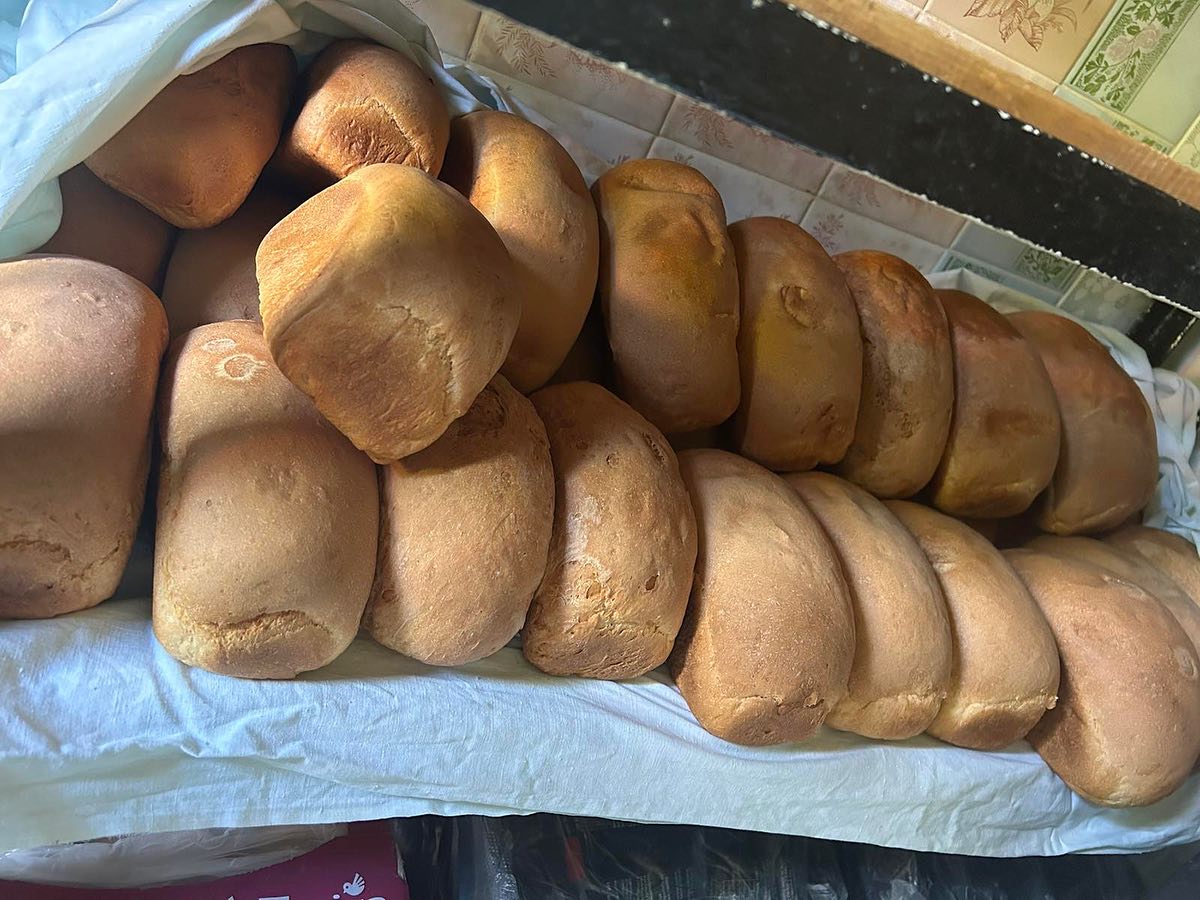 A bunch of bread sitting on a table in front of a counter.