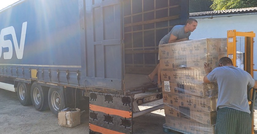 Two men loading boxes onto a truck.