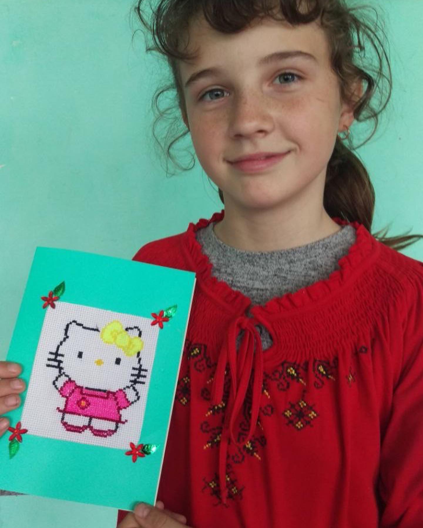 A girl holding up a hello kitty card.