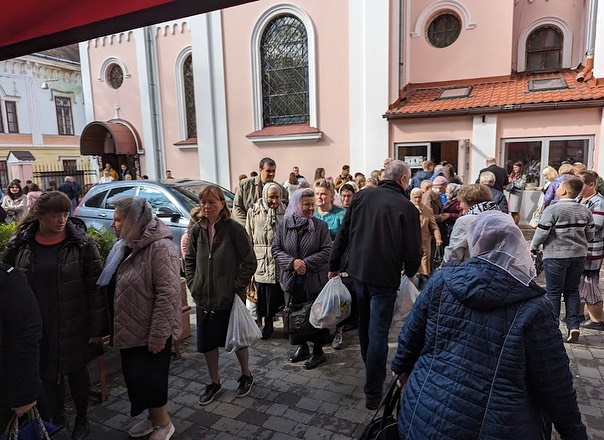 A crowd of people standing outside of a church.