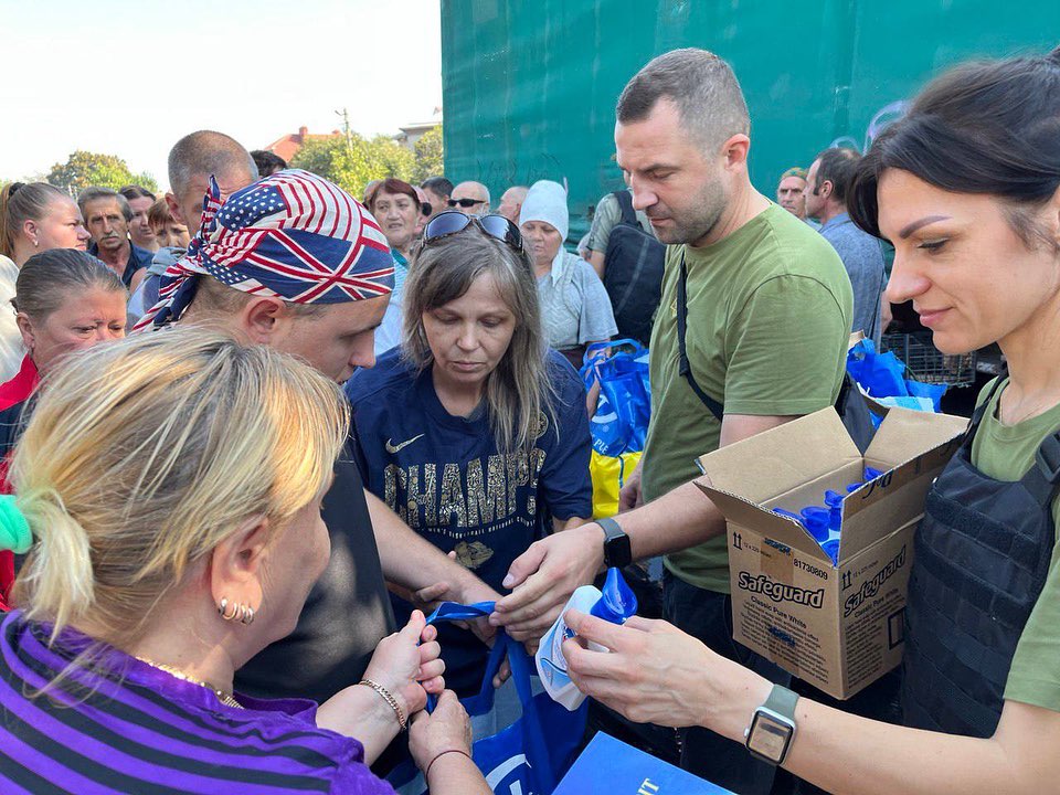 A group of people are handing out food to a crowd.