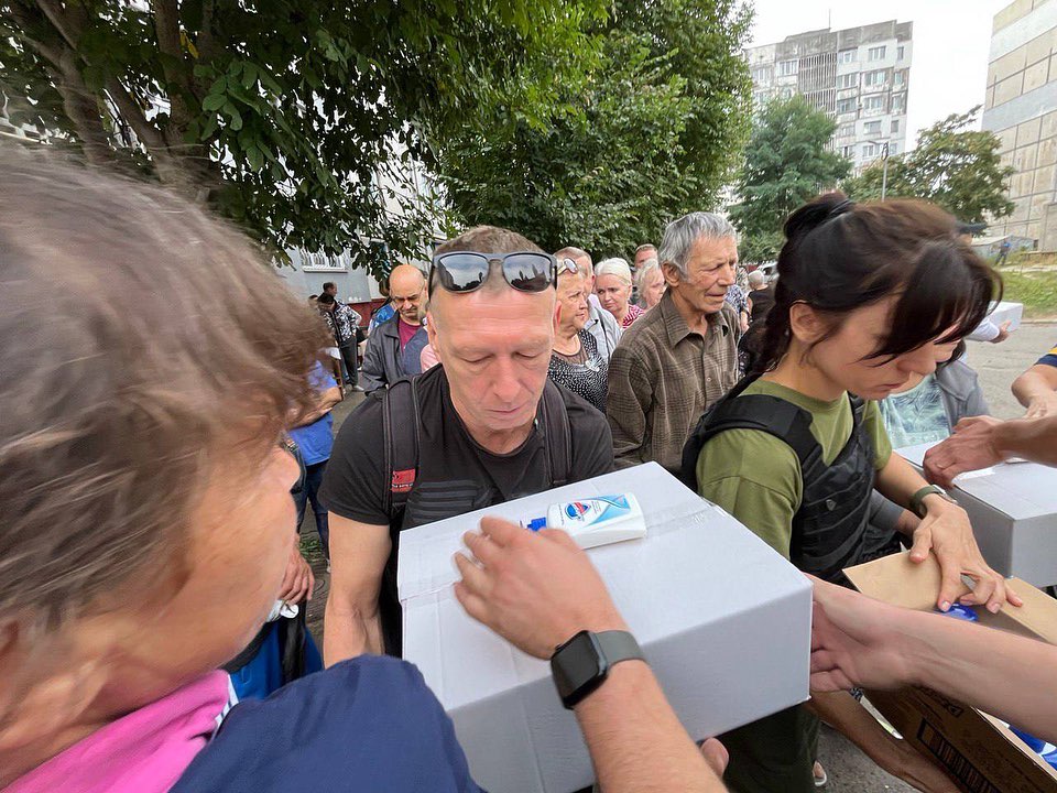 A group of people are gathered around a box.