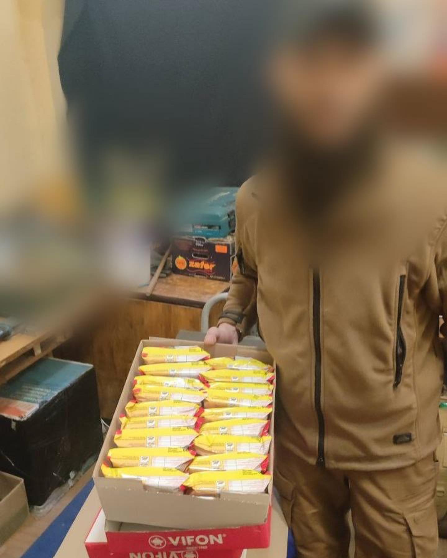 A man standing next to a box of food.