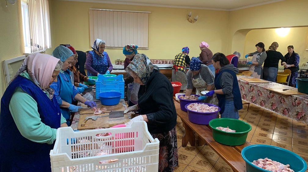 A group of women are preparing food in a room.