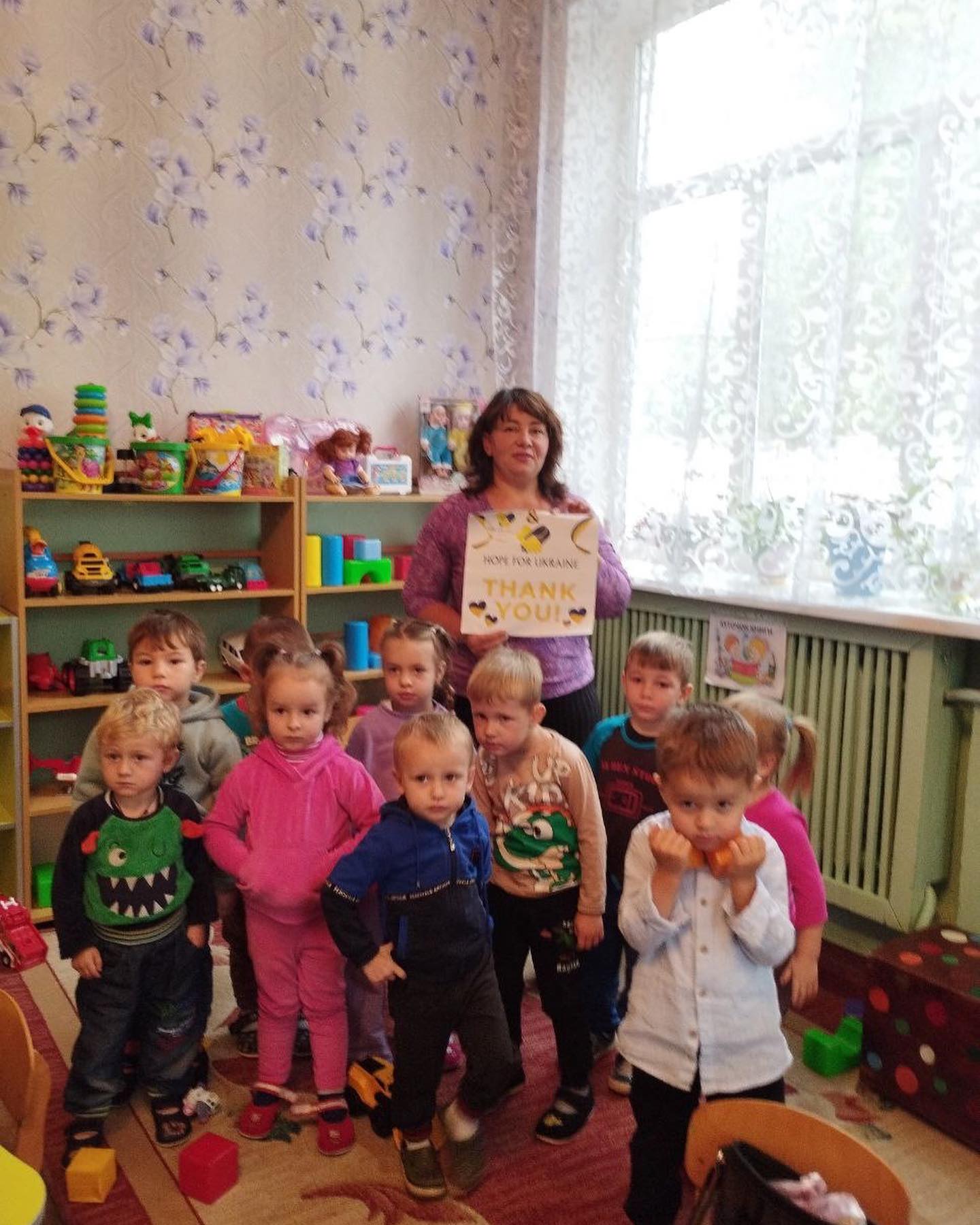 A group of children posing for a picture in a playroom.