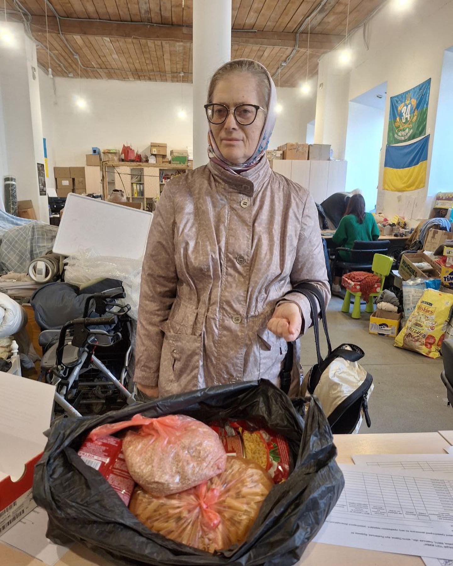 A woman standing next to a bag of food.