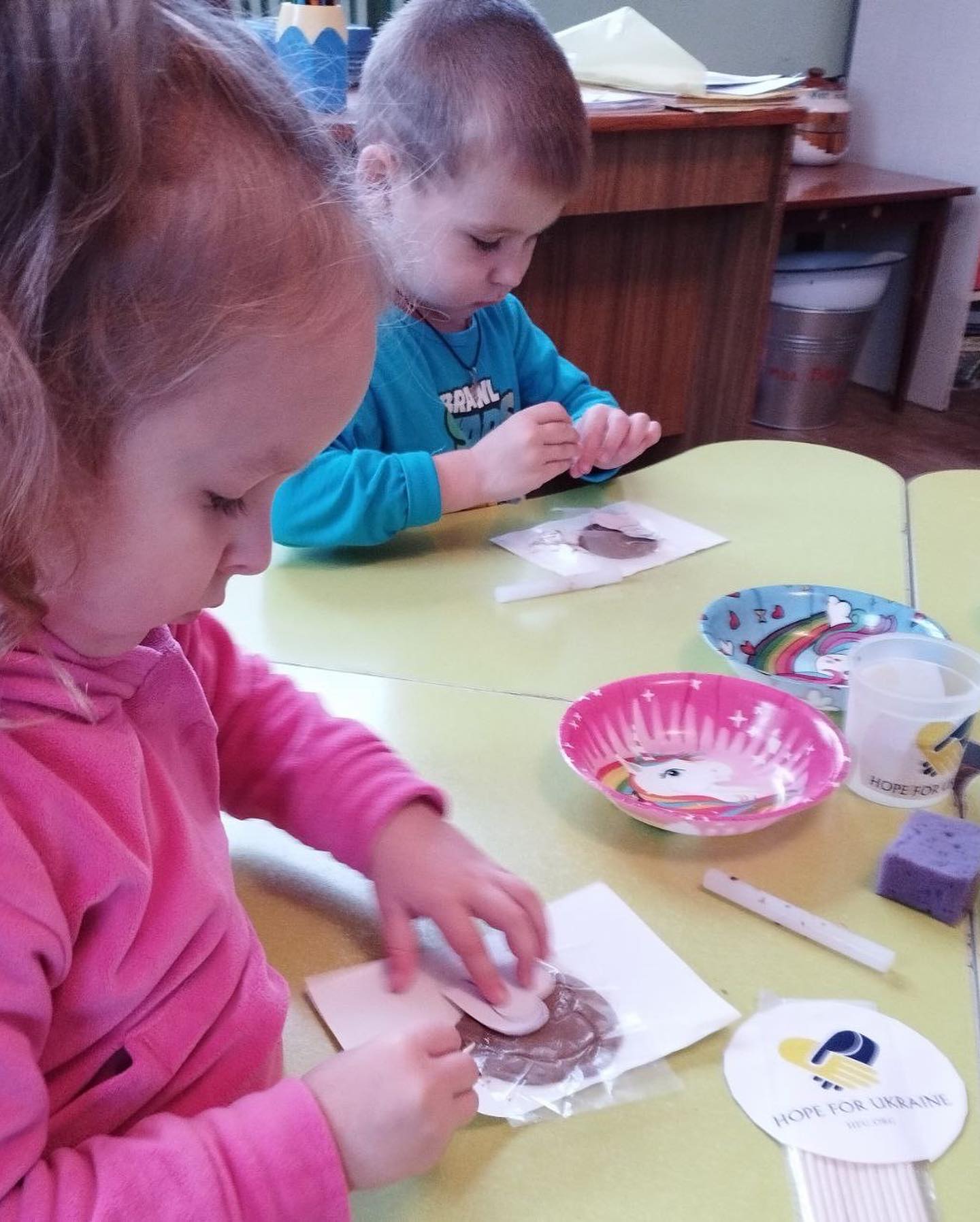 Two children are making crafts at a table.